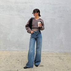 Influencer @tamaramory wears stud-embellished jeans with a brown cardigan and black bag.