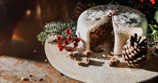 A marzipan covered traditional Christmas fruit cake, decorated with holly, berries, and acorns.