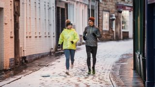 Woman running with young man wearing workout clothes, representing the social benefits of exercise in winter