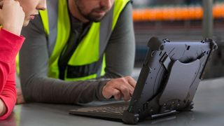 Two workers look at a MobileDemand Flex 10B rugged tablet