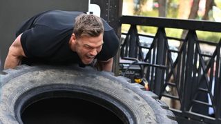 Alan Ritchson flipping a tire