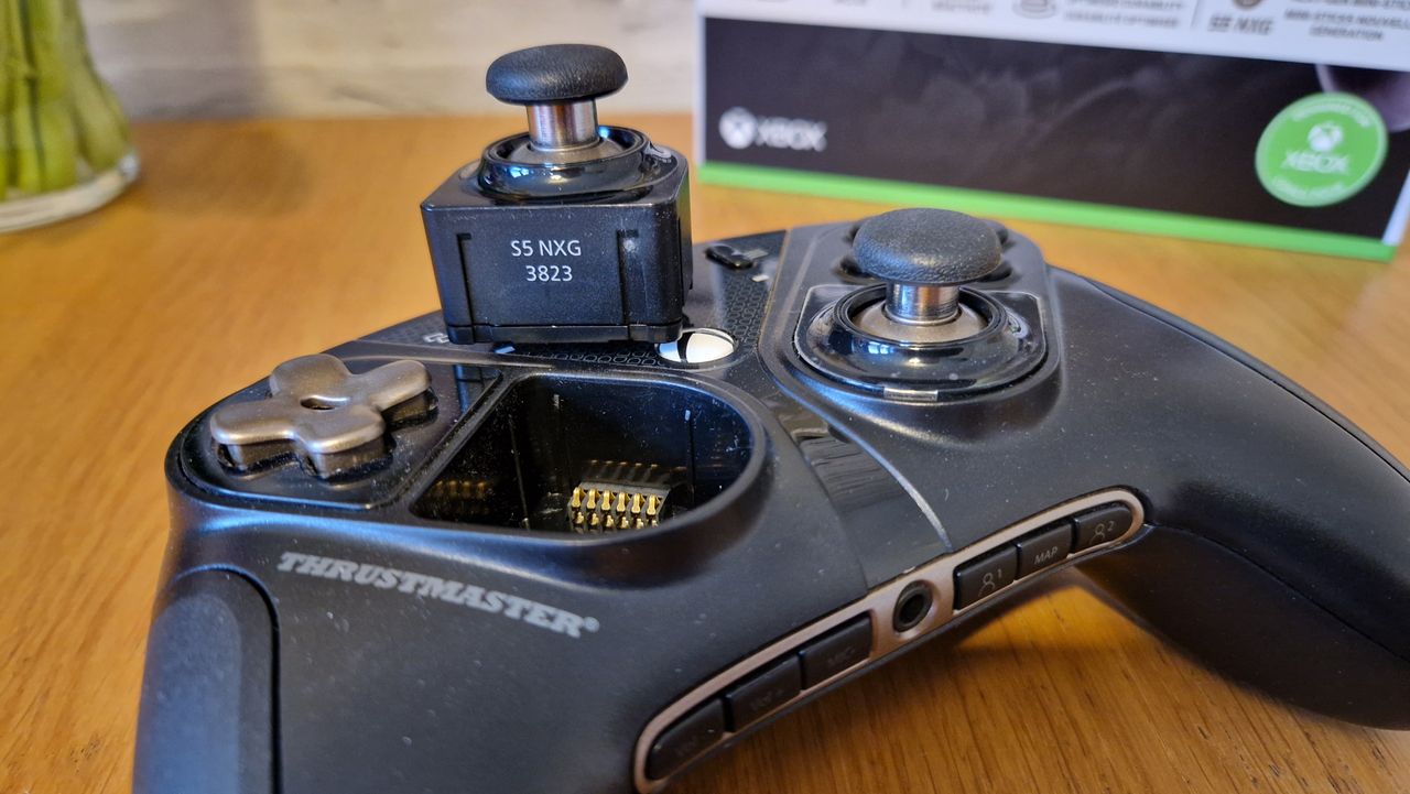 The Thrustmaster eSwap X2 controller on a wooden surface