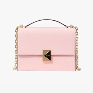 A cutout of a small Kate Spade blush pink bag shot against a light background