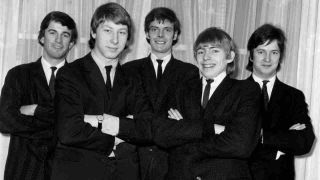 The Yardbirds posing for a photograph in black suits in 1965