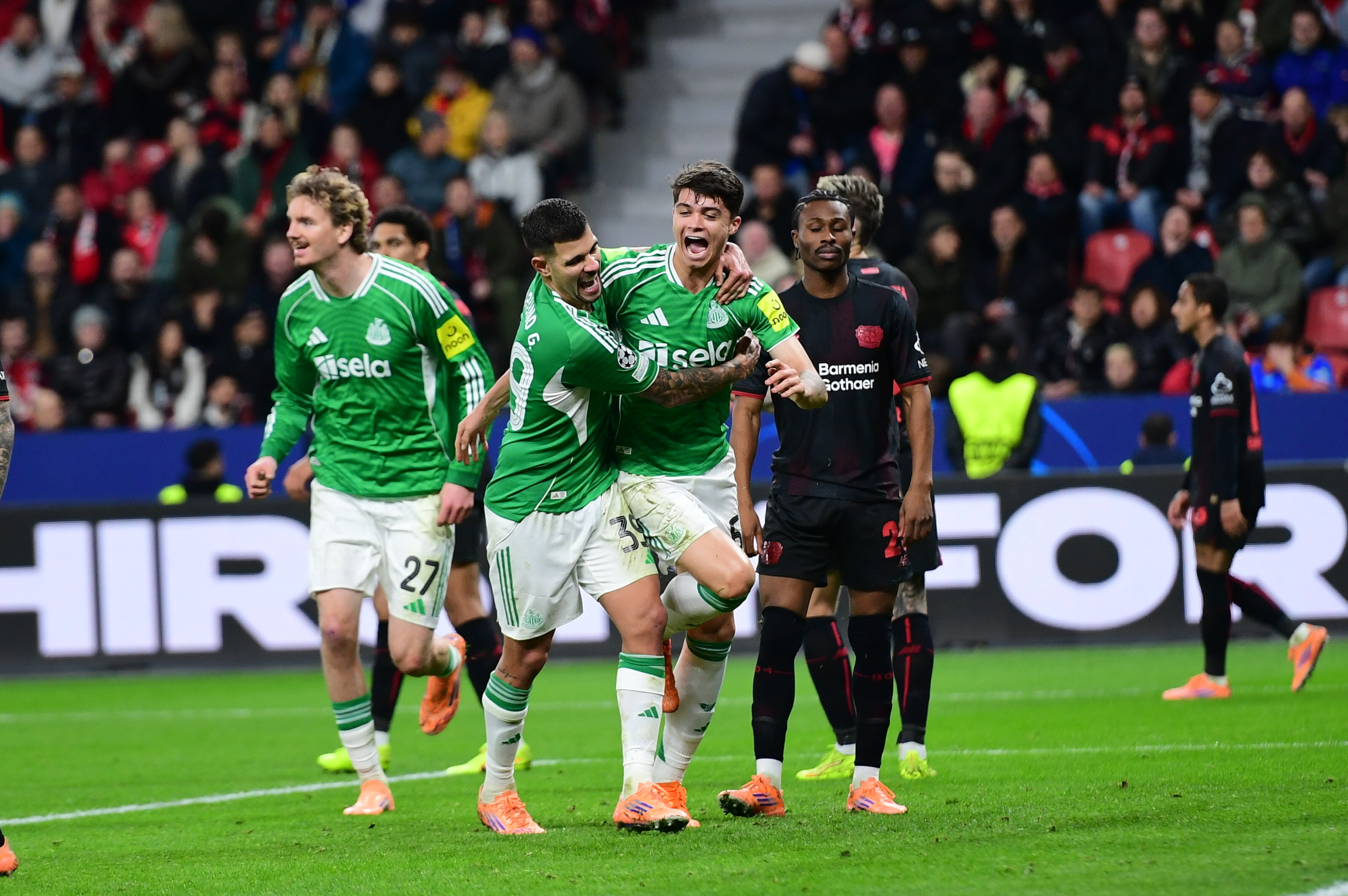 LEVERKUSEN, GERMANY - DECEMBER 10: Lewis Miley of Newcastle United (67) celebrates with teammates after scoring a goal during the UEFA Champions League match between Bayer 04 Leverkusen and Newcastle United FC at BayArena on December 10, 2025 in Leverkusen, Germany. (Photo by Hesham Elsherif/Anadolu via Getty Images)