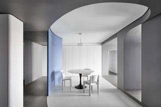 Origin Realm by XIGO Studio - a minimalist room with a white round table with black stem and three white chairs.