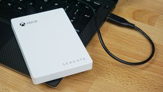 The Seagate Game Drive for Xbox One and Xbox Series X|S connected via USB to a laptop.