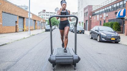 Assault AirRunner Review: female athlete running on the AirRunner on a city street