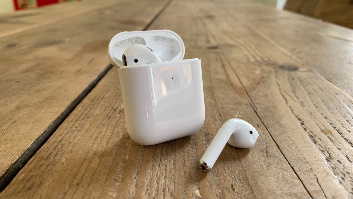 Apple AirPods 2 on a table with one earbud out of the charging case