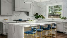 luxury marble kitchen with blue and gold bar stools