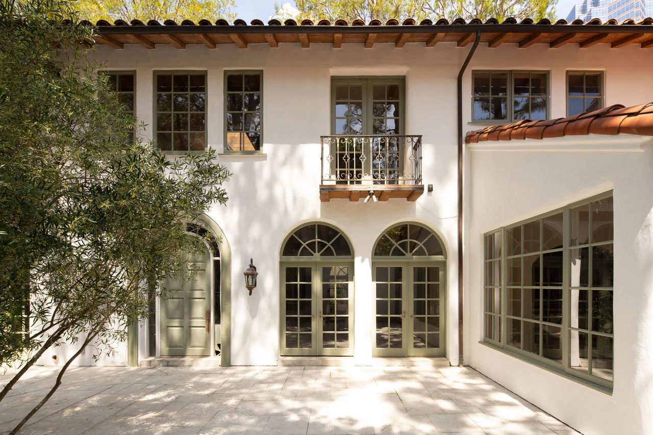 An exterior space with muted tiles, and green windows