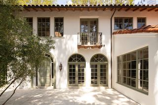 An exterior space with muted tiles, and green windows