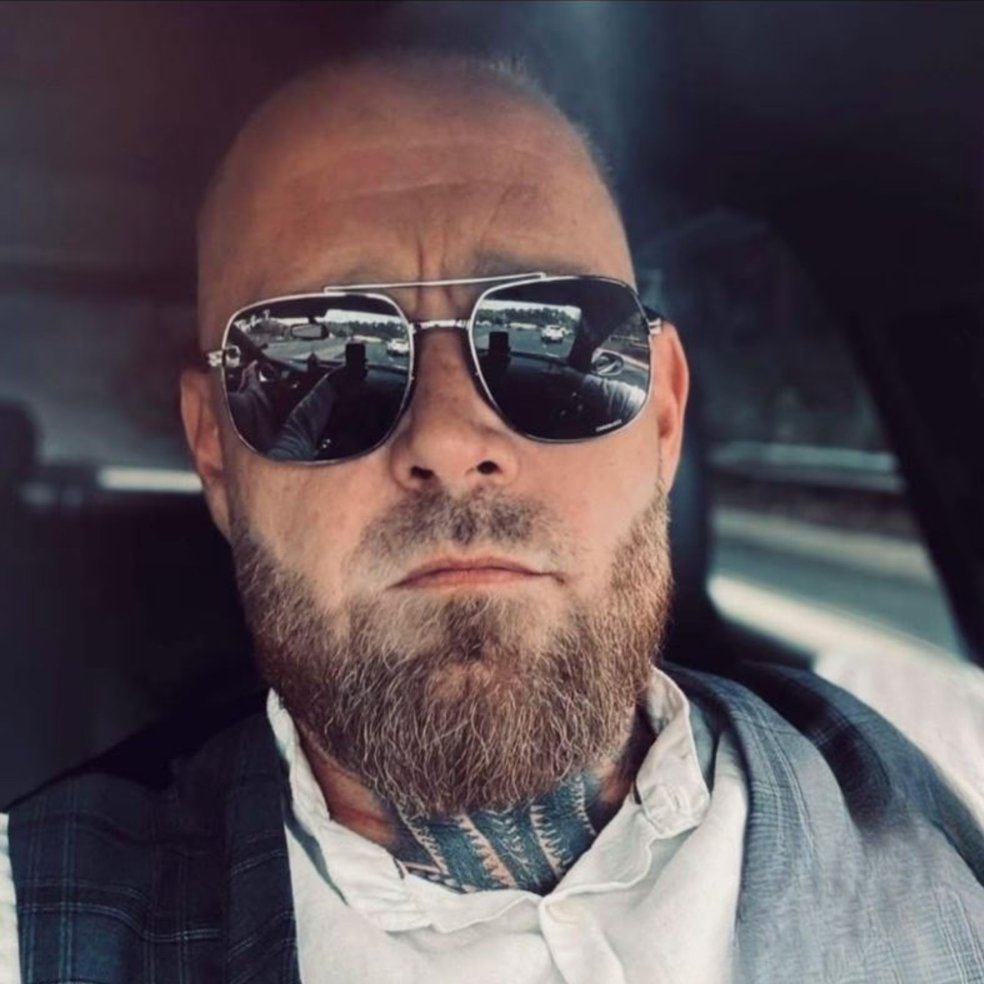 John Duthart headshot shows a white man with a brown beard wearing sunglasses