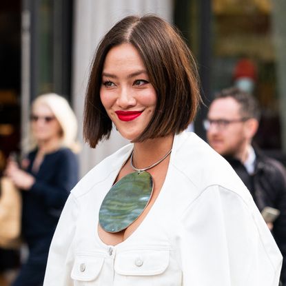 Tiffany Hsu wears a cream denim jacket with matching maxi skirt, black bag and big round necklace, outside The Row, during the Womenswear Spring/Summer 2024 as part of Paris Fashion Week on September 27, 2023 in Paris, France