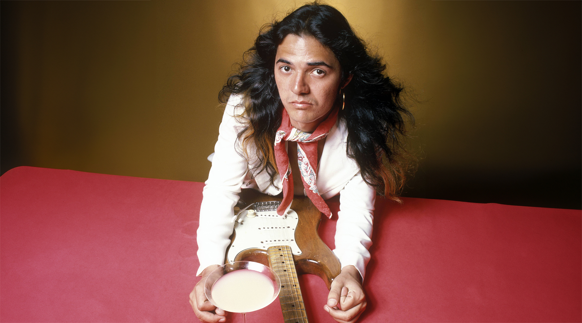 Tommy Bolin, posed with guitar and cocktail, June 1975
