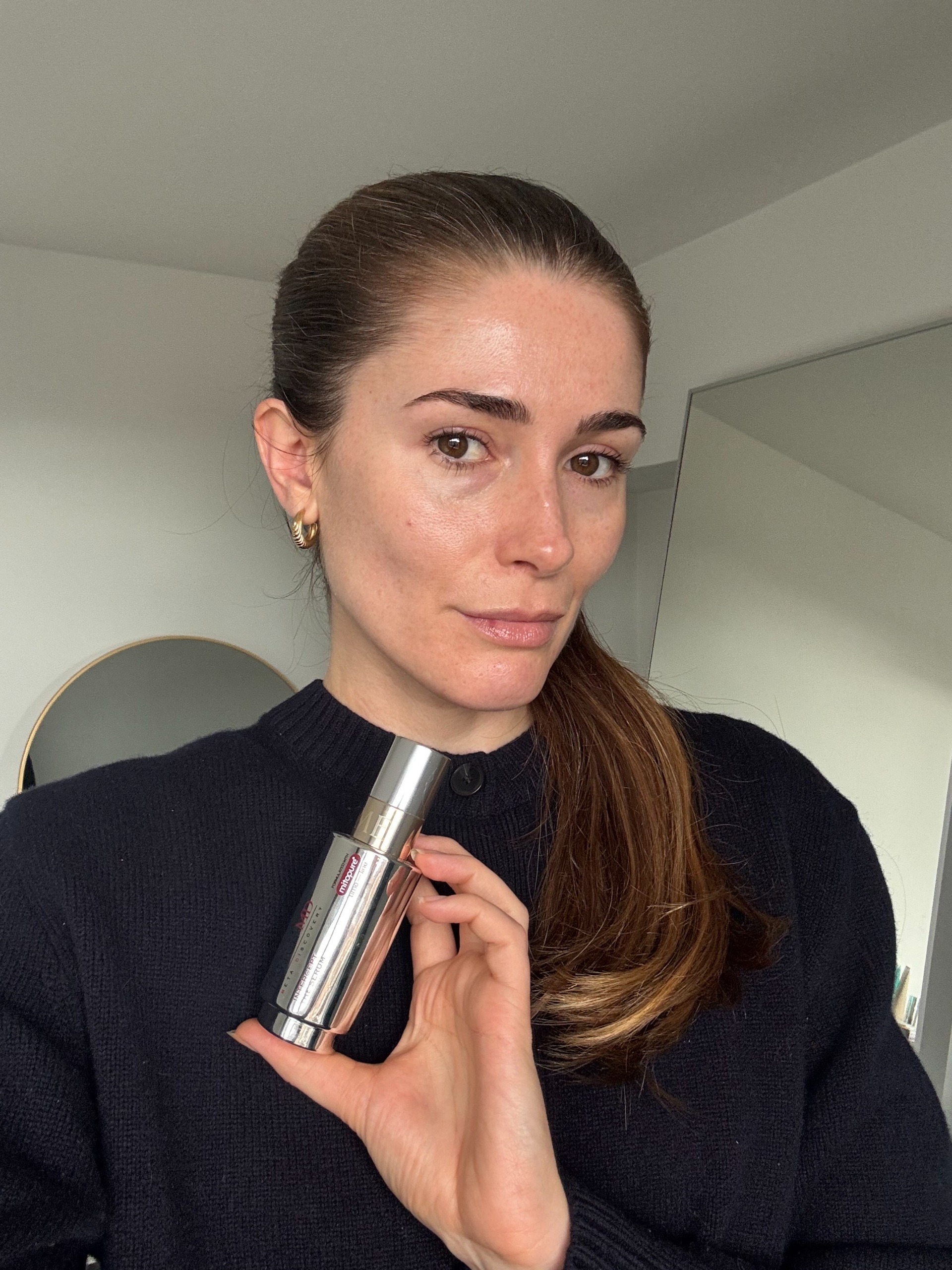 Eleanor holding a bottle of the Lancome Absolu Longevity MD Anticipate Cream in her hand