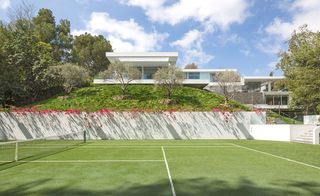 The home's carefully landscaped gardens include a tennis court and a sunken gym