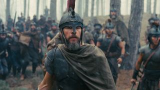 Matt Damon in his helmet standing in front of soldiers in The Odyssey