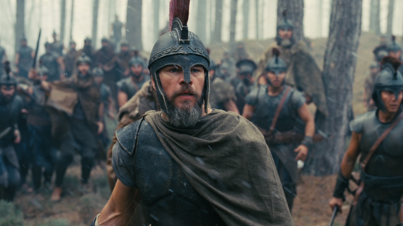 Matt Damon in his helmet standing in front of soldiers in The Odyssey