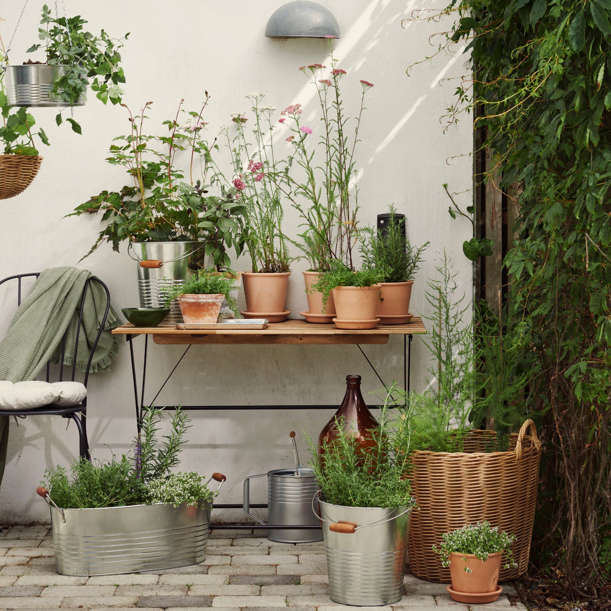 IKEA Hanging steel basket and steel planters next to a potting bench.
