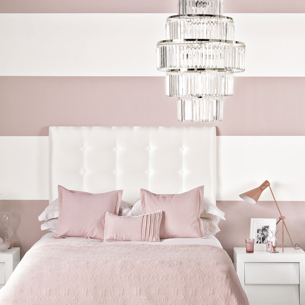 chic pink and white bedroom with chandelier