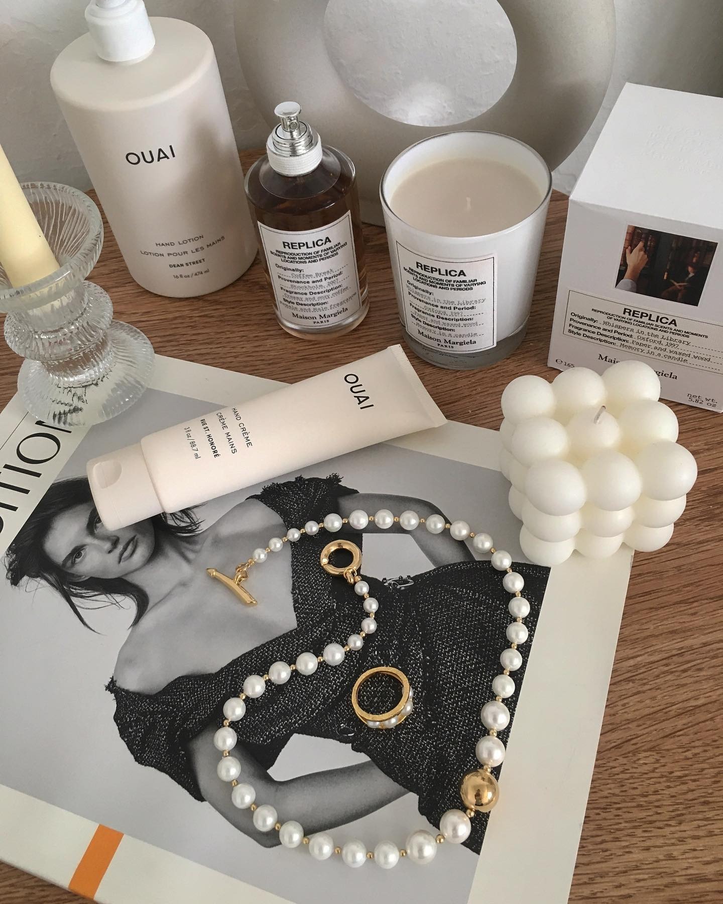 A picture of a coffee table with a stylish book and a Maison Margiela candle