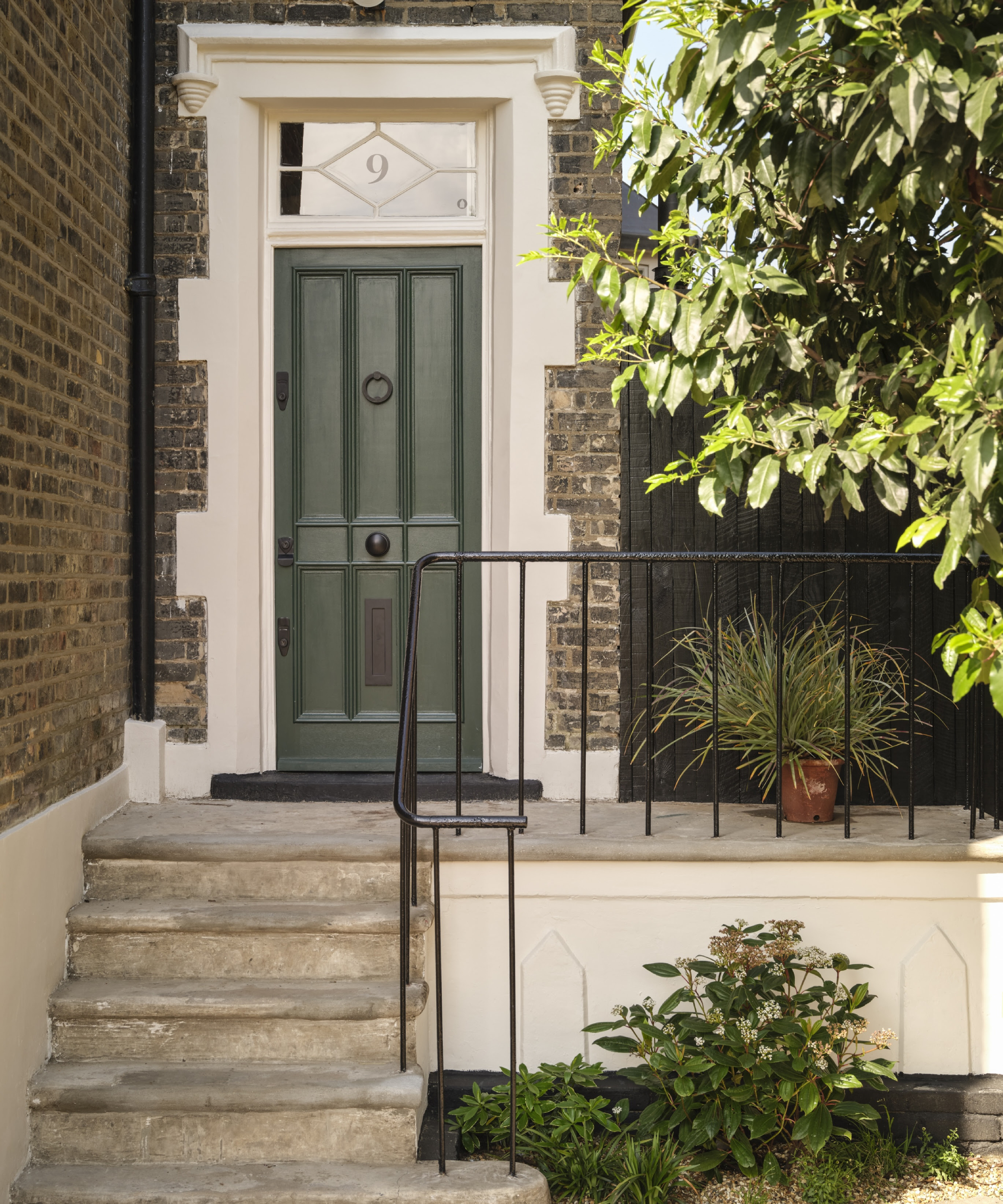 entrance to home with steps leading to rich green front door and cream paintwork
