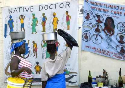 Women look at banners promoting health awareness in Monrovia, Liberia.