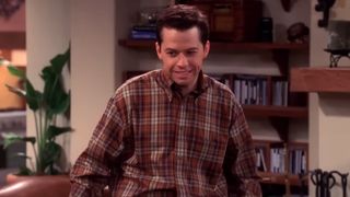 A screenshot of Jon Cryer standing in the living room in Two and a Half Men.