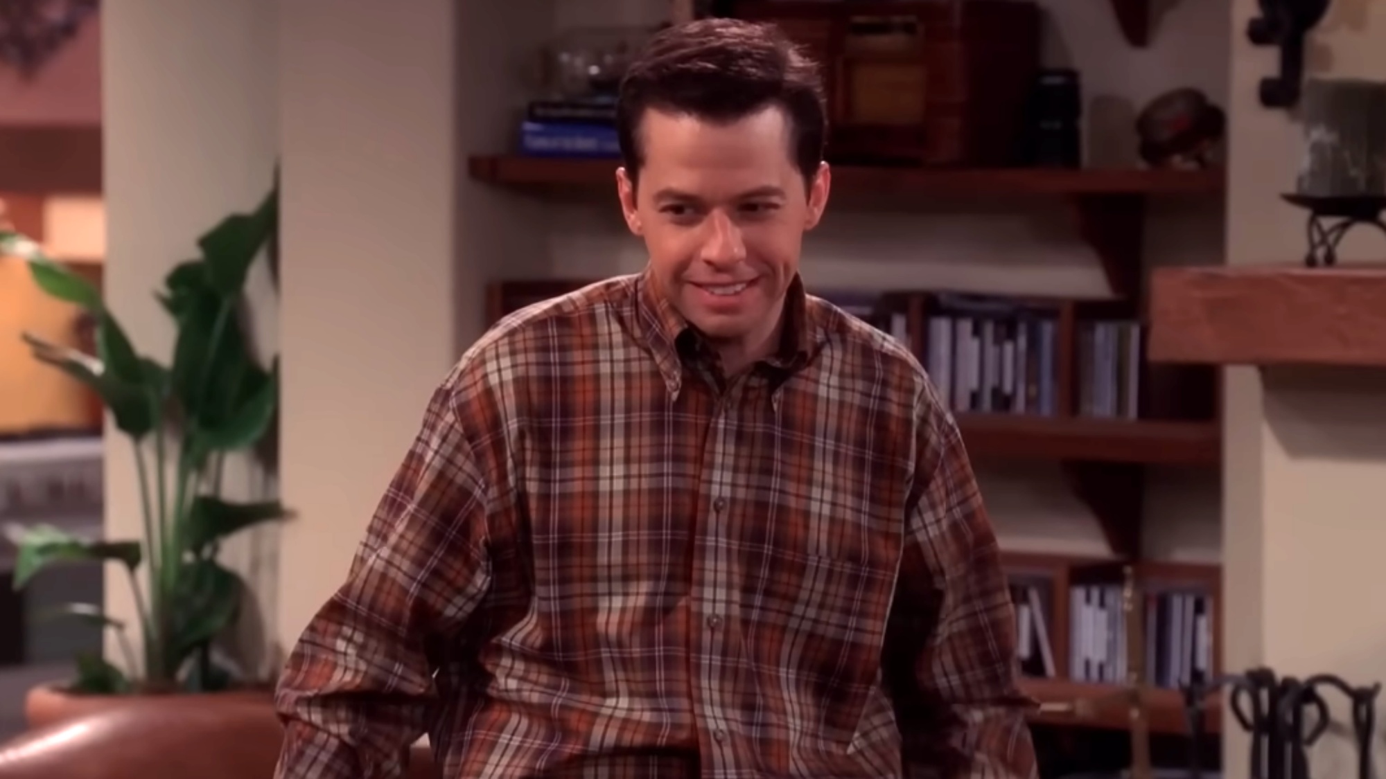 A screenshot of Jon Cryer standing in the living room in Two and a Half Men.