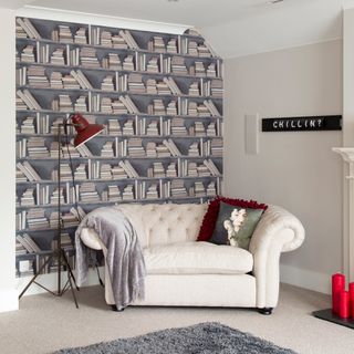 Living room with bookcase wallpaper and a white sofa