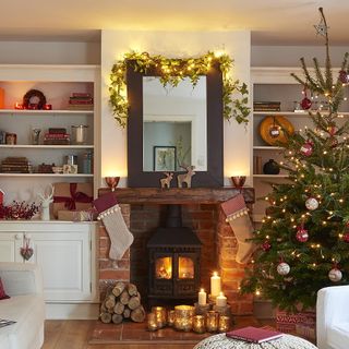Wood burning stove, with lit candles and a decorated Christmas tree