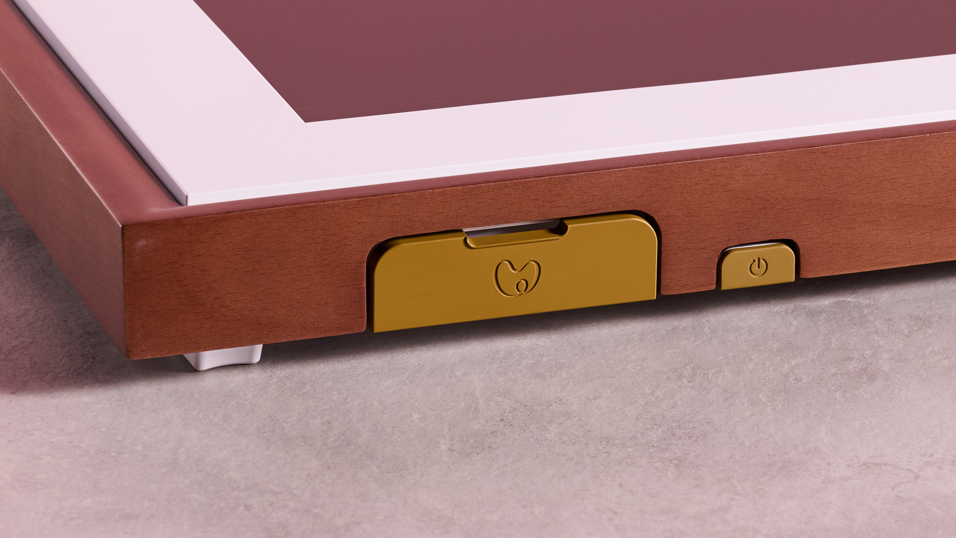 The wood effect frame of Netgear Meural Canvas II, showing a closed foldout section.