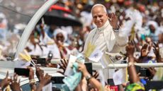 Pope Leo XIV waves to crowds from the Popemobile