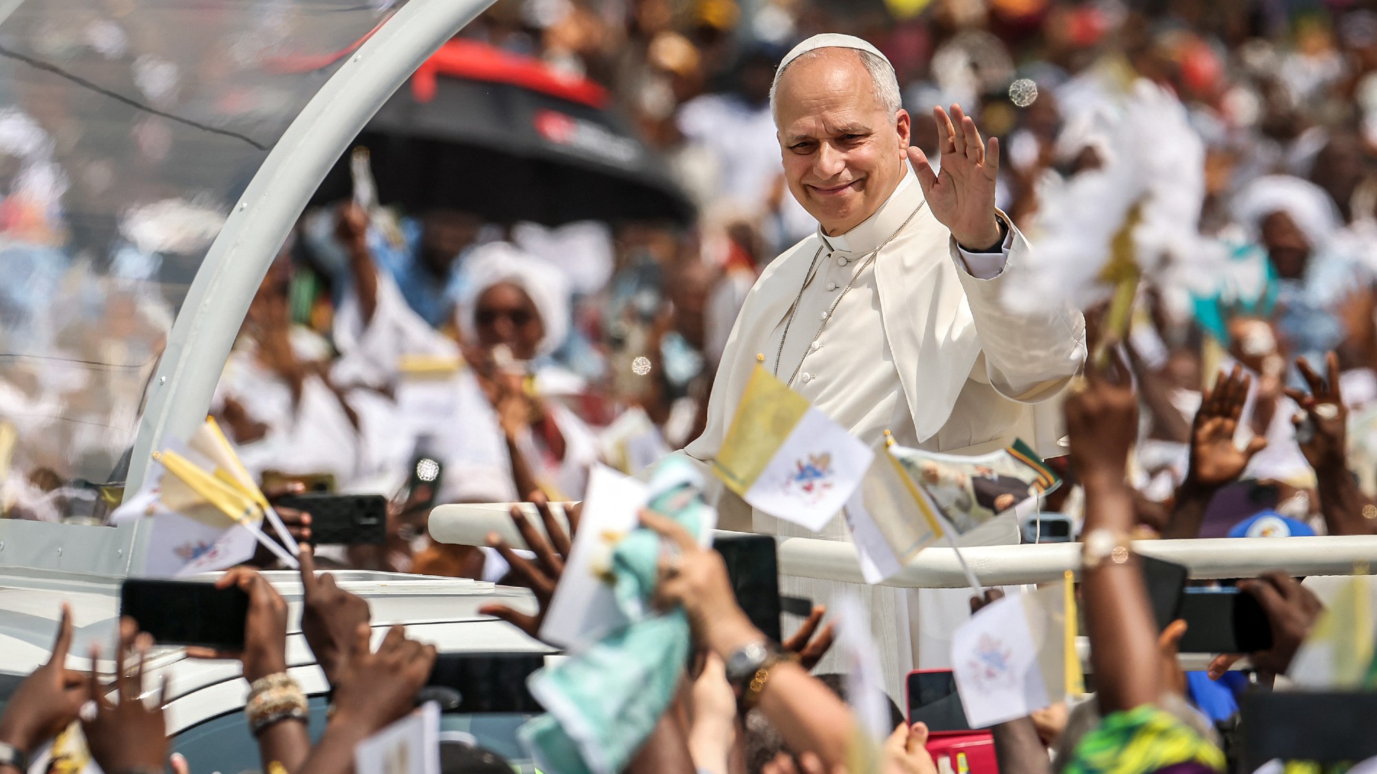 Pope Leo XIV waves to crowds from the Popemobile