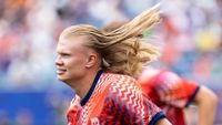 Erling Haaland on the pitch with his hair flowing behind him 