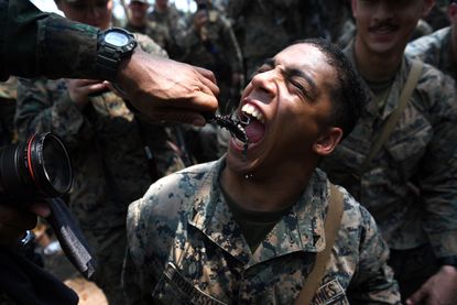 A US Marine eats a scorpion during a jungle survival training.