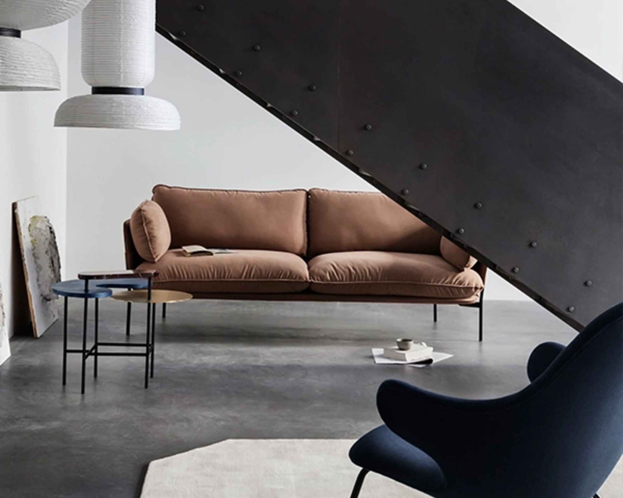 A contemporary couch with minimal black metal frame and brown upholstery in a modern living space