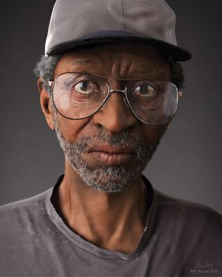 Portrait of a man wearing glasses and a cap