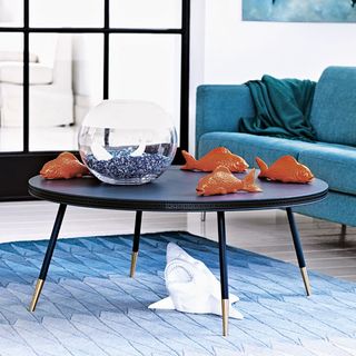 sea theme living room round table with glass bowl blue sofa blue rug and fishes
