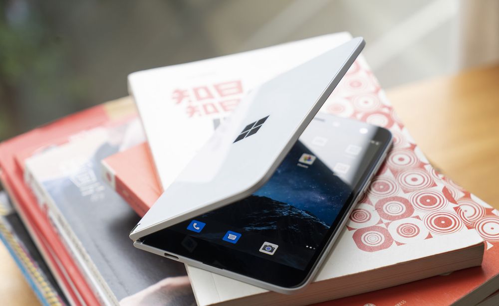 Microsoft&amp;#039;s Surface Duo on top of a pile of books