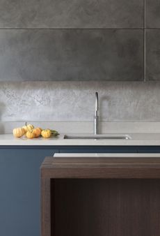 Concrete effect cabinets, backsplash, white marble countertops in a modern handlelesskitchen