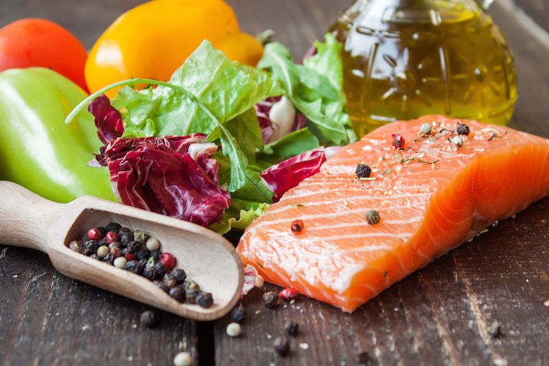 A meal of olive oil, salmon, and vegetables