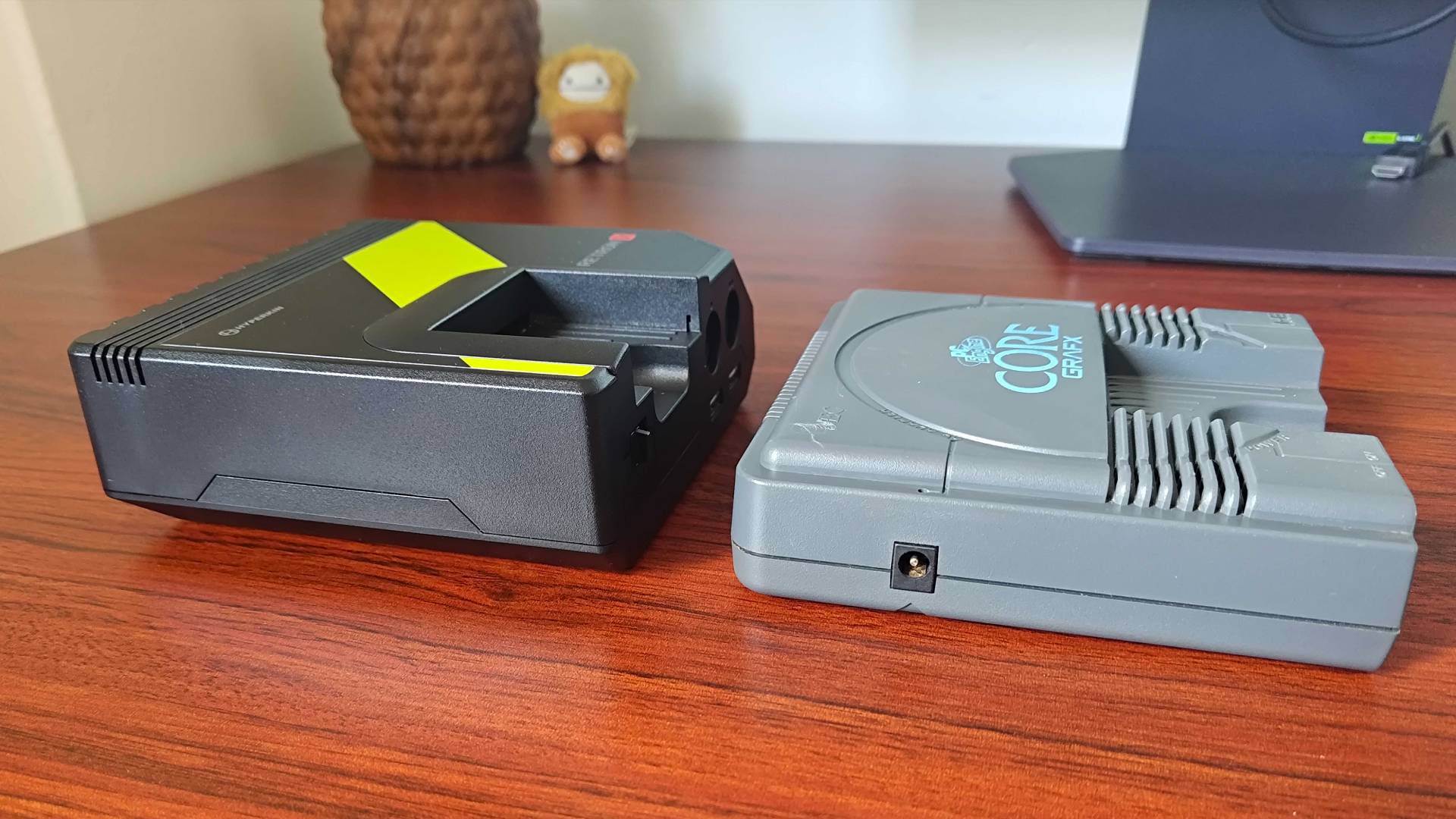 Side views of Hyperkin Retron GX next to PC Engine on woodgrain desk.