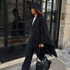 A woman in Paris wearing a stylish, all-black winter outfit