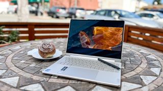 Lenovo Yoga 9i Gen 8 review unit on a table outdoors, Sonic the Hedgehog 2 playing on the screen