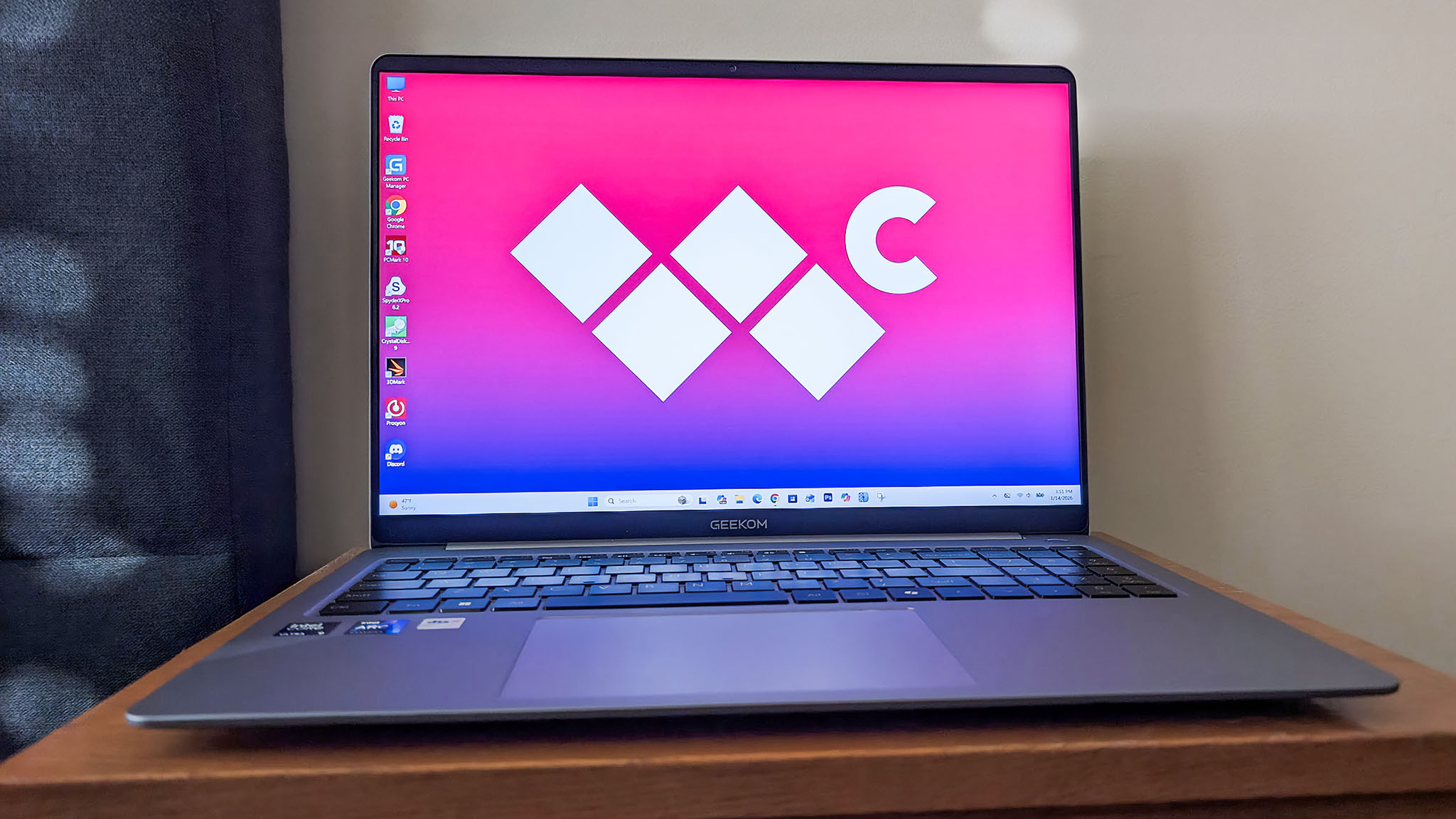 Geekom Geekbook X16 Pro on an end table with screen pointed toward the viewer.