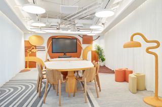 A colourful meeting room with orange and yellow furniture