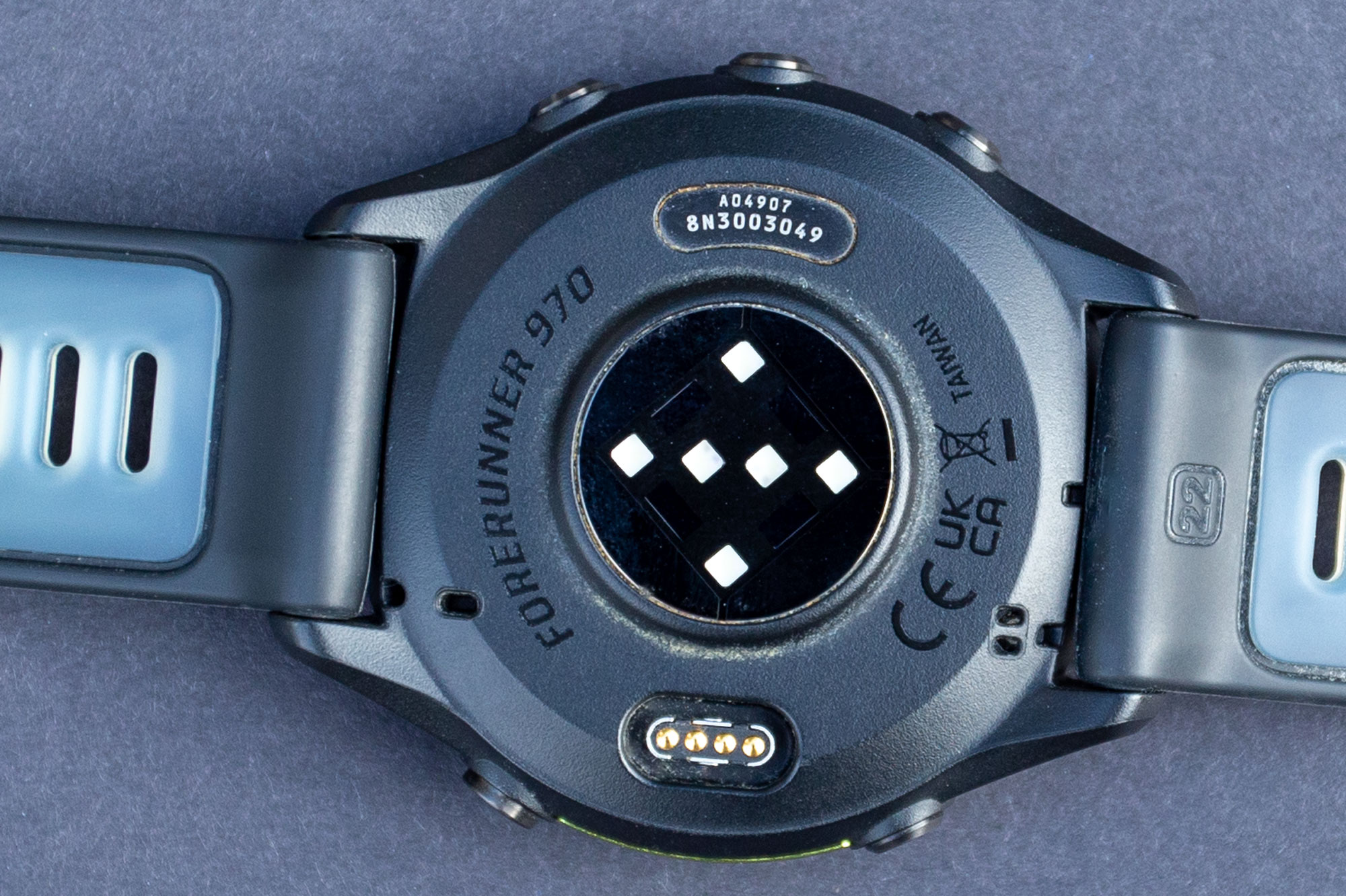 The underside of the Garmin Forerunner 970's case, showing the optical sensor and power socket.