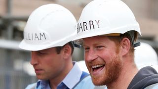 Prince Harry and Prince William wearing hard hats with their names on
